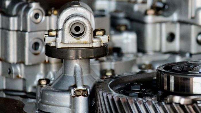A drivetrain assembly on a production line, gear sets and housings in frame.