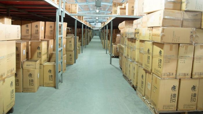 A warehouse aisle of pallet racking stacked to the roof.